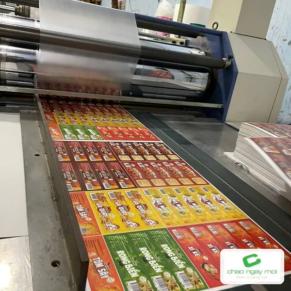 Tờ in đang đi qua m&aacute;y c&aacute;n m&agrave;ng c&ocirc;ng nghiệp
